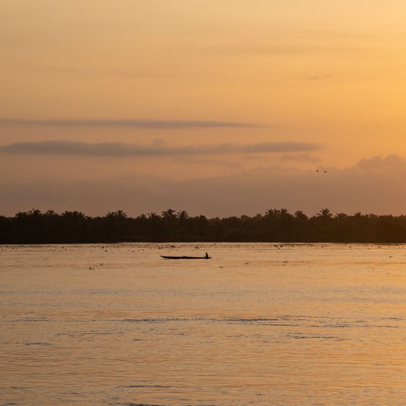Sunrise photo a a fisherman in his boat on the Magdalena River.