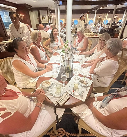 Red Orchid Travel Women's Club group at the celebration dinner where everyone wears white, while on the Star Clipper.