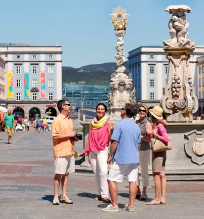 A group of travellers standing near statues on a luxury tour.